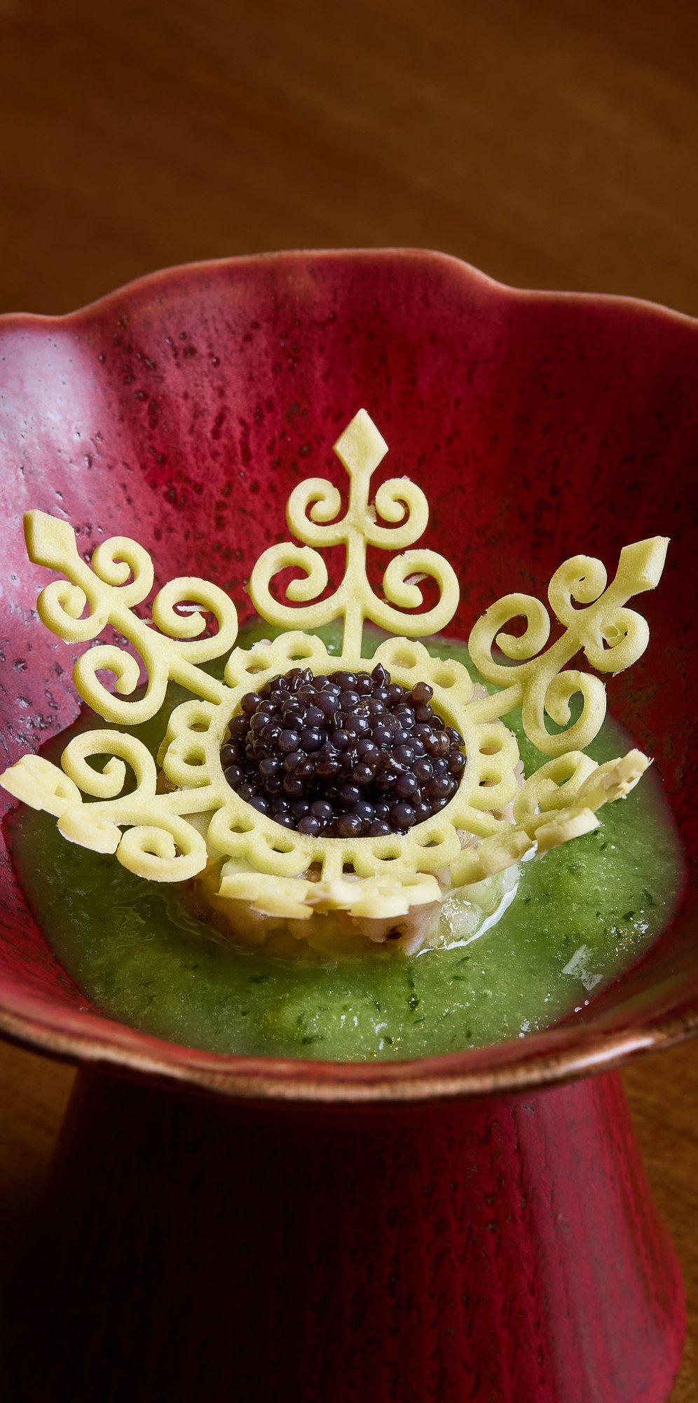 Canapé with black caviar in a red ceramic bowl