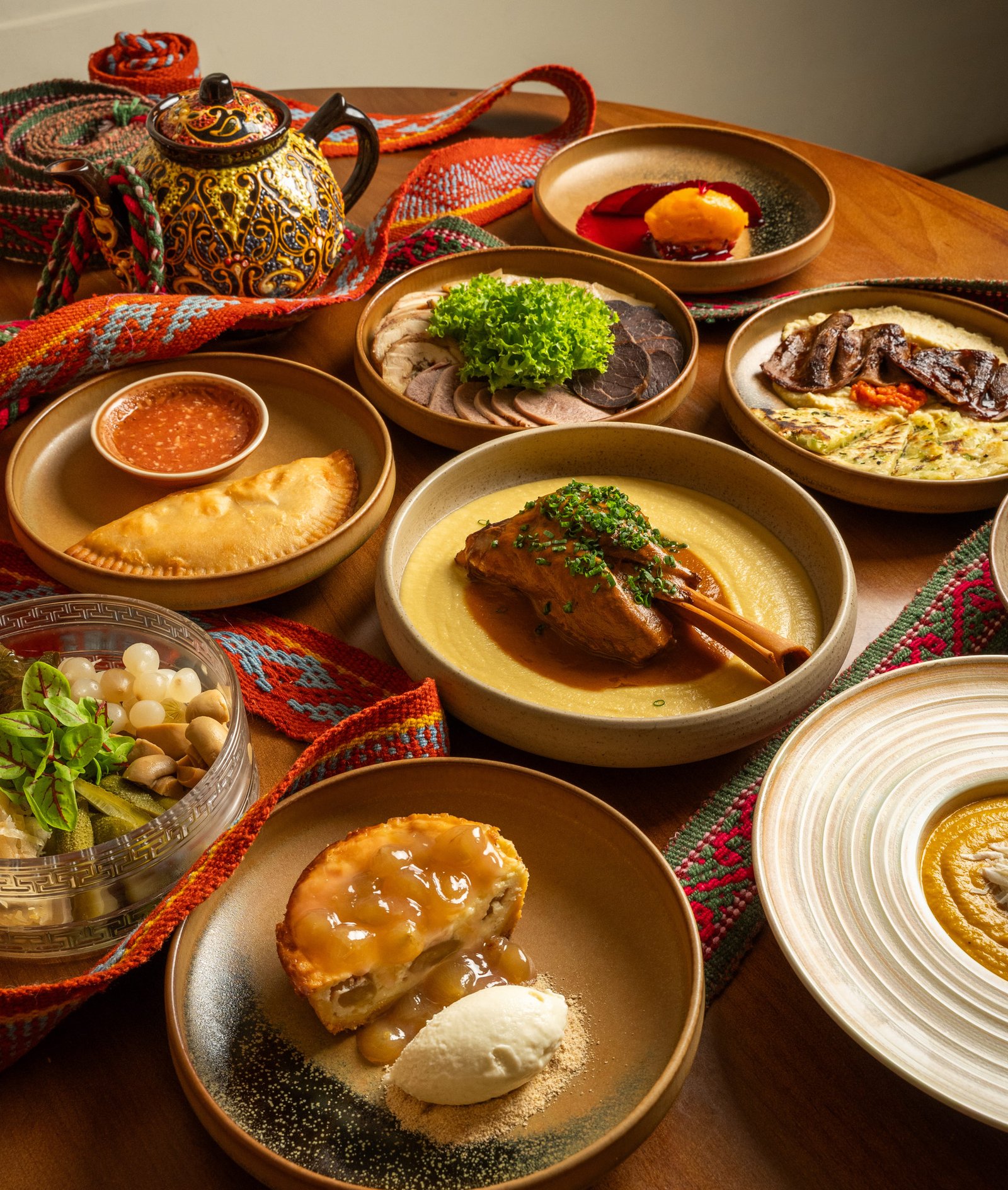 A spread of YURT dishes on a table with a painted teapot